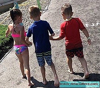 The touching gesture of two five-year-old children helping a friend with cerebral palsy walk