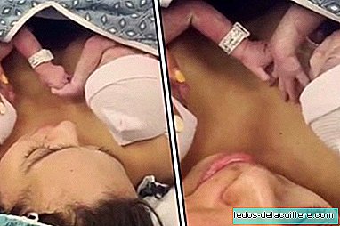 The emotional moment in which two identical twins hold hands minutes after birth