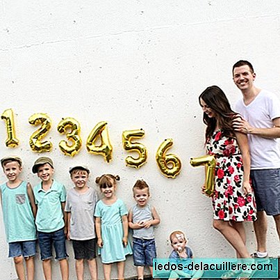 Legrační fotografie rodiny oznamující, že dítě číslo sedm je na cestě