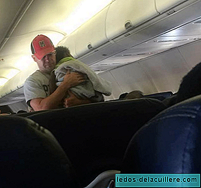 Bir erkek, uçuşta bir kadının bebeğiyle ilgilenir ve yardımcı olabilecek küçük hareketlerin olduğunu gösterir.