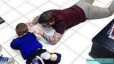 O cabeleireiro deitado no chão para cortar o cabelo de uma criança com autismo que sempre fugia dele
