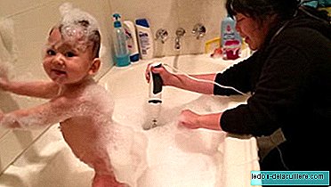 يا له من طيش! تستخدم الأم الخلاط الكهربائي لرغوة بينما تستحم طفلها
